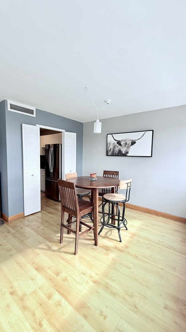 6301 North Sheridan Road, Unit 19V Chicago, IL 60660 - Photo 9 of 16 a view of a dining room with furniture and wooden floor