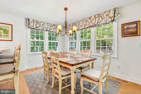 a dining room with furniture a chandelier and wooden floor