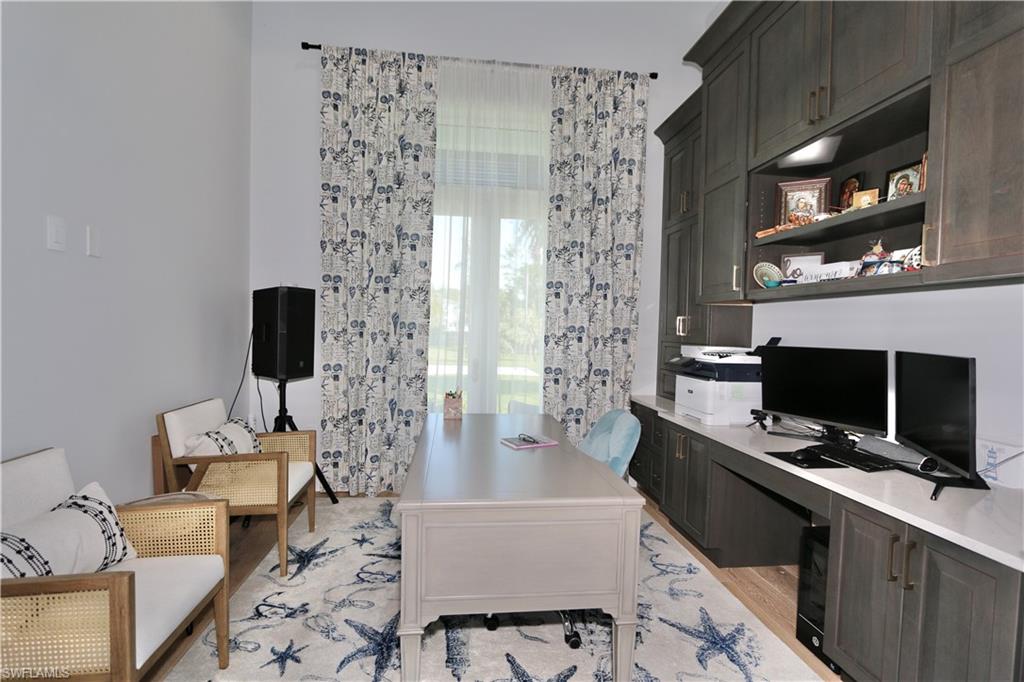 6688 Hunters Road Naples, FL 34109 - Photo 12 of 43 a living room with furniture a flat screen tv and a fireplace