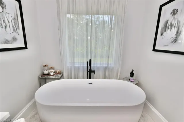 a bathroom with a bathtub sink and mirror