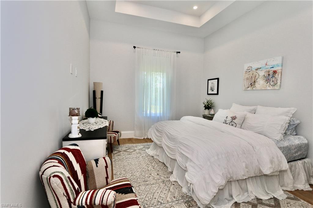 6688 Hunters Road Naples, FL 34109 - Photo 20 of 43 a bedroom with a bed and wooden floor