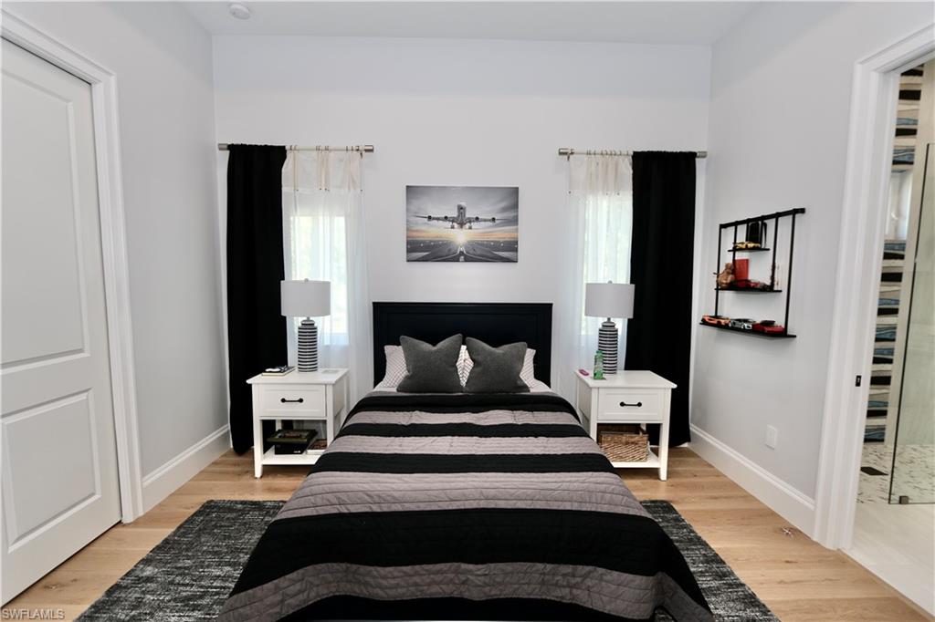 6688 Hunters Road Naples, FL 34109 - Photo 23 of 43 a bedroom with a bed and wooden floor