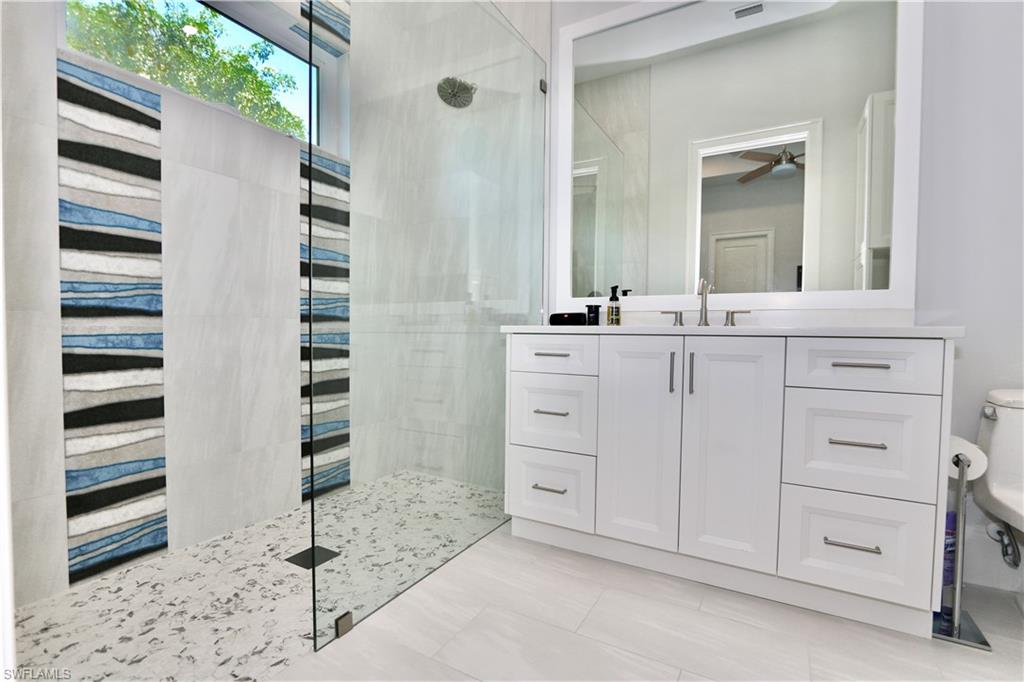 6688 Hunters Road Naples, FL 34109 - Photo 24 of 43 a bathroom with a double vanity sink and mirror