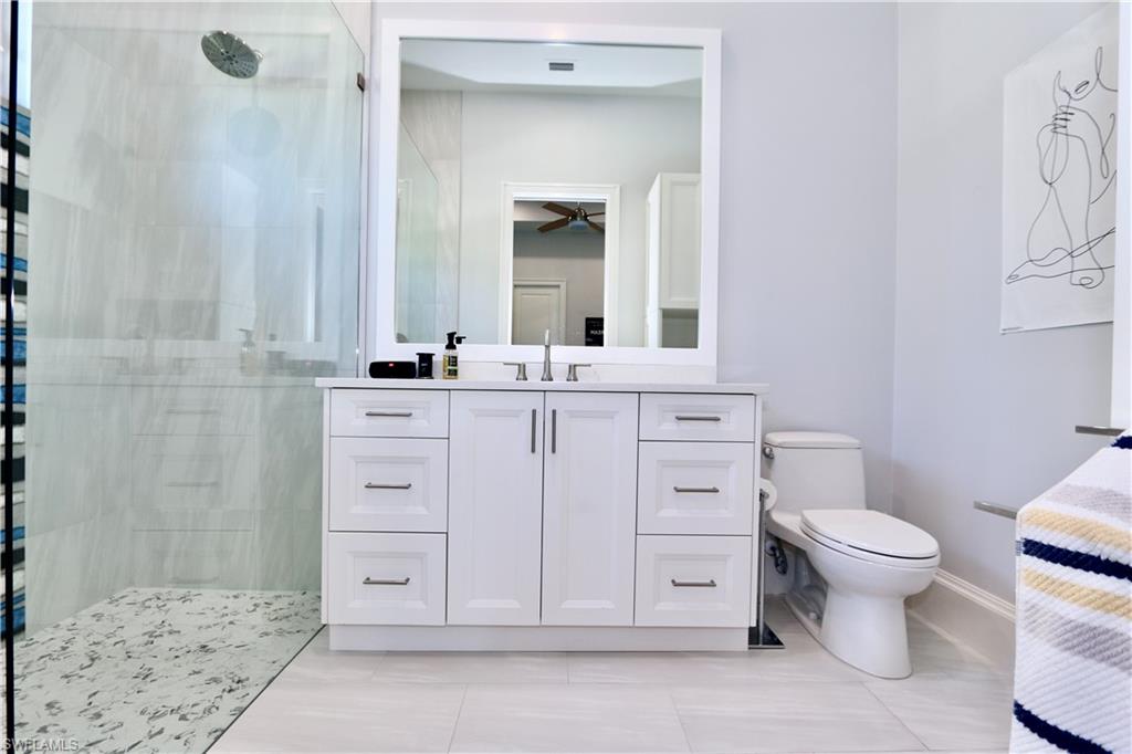 6688 Hunters Road Naples, FL 34109 - Photo 25 of 43 a bathroom with a toilet sink and mirror
