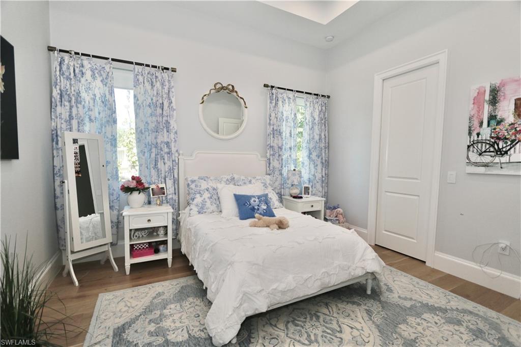 6688 Hunters Road Naples, FL 34109 - Photo 26 of 43 a bedroom with a bed a mirror and a window