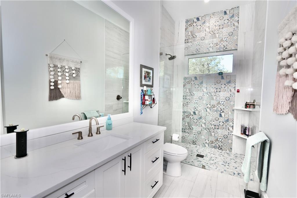 6688 Hunters Road Naples, FL 34109 - Photo 28 of 43 a bathroom with a sink toilet and shower