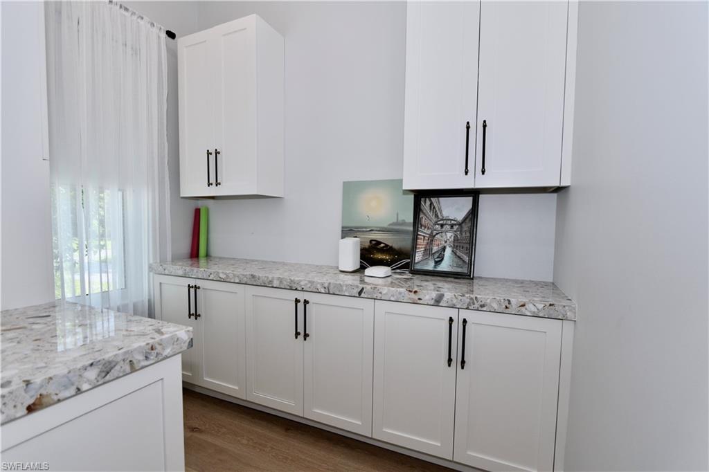 6688 Hunters Road Naples, FL 34109 - Photo 30 of 43 a kitchen with granite countertop white cabinets and white appliances