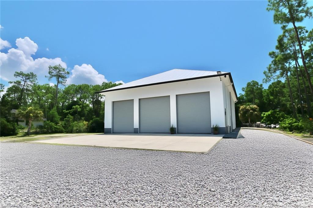 6688 Hunters Road Naples, FL 34109 - Photo 39 of 43 a front view of a house with a yard and garage