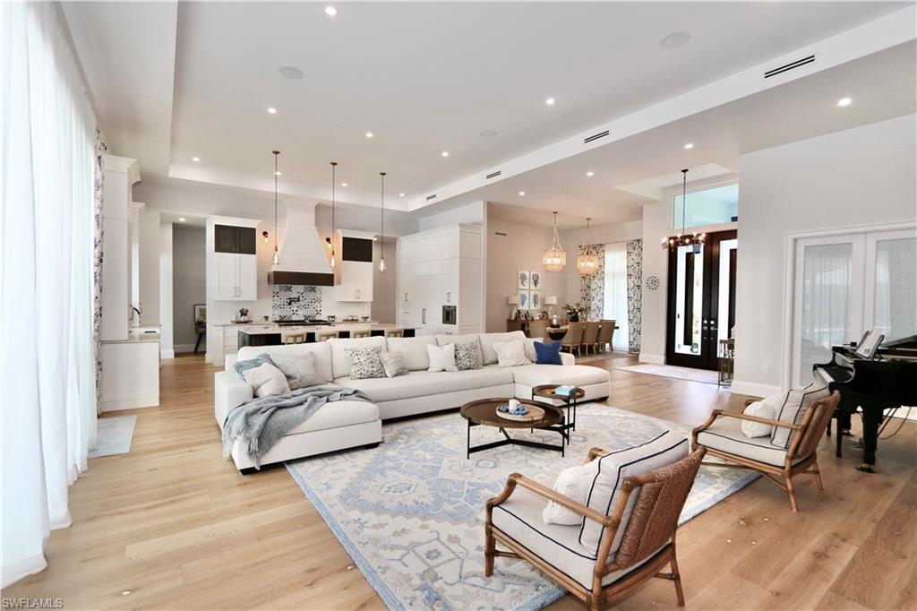 6688 Hunters Road Naples, FL 34109 - Photo 6 of 43 a living room with stainless steel appliances kitchen island granite countertop a couch and cabinets
