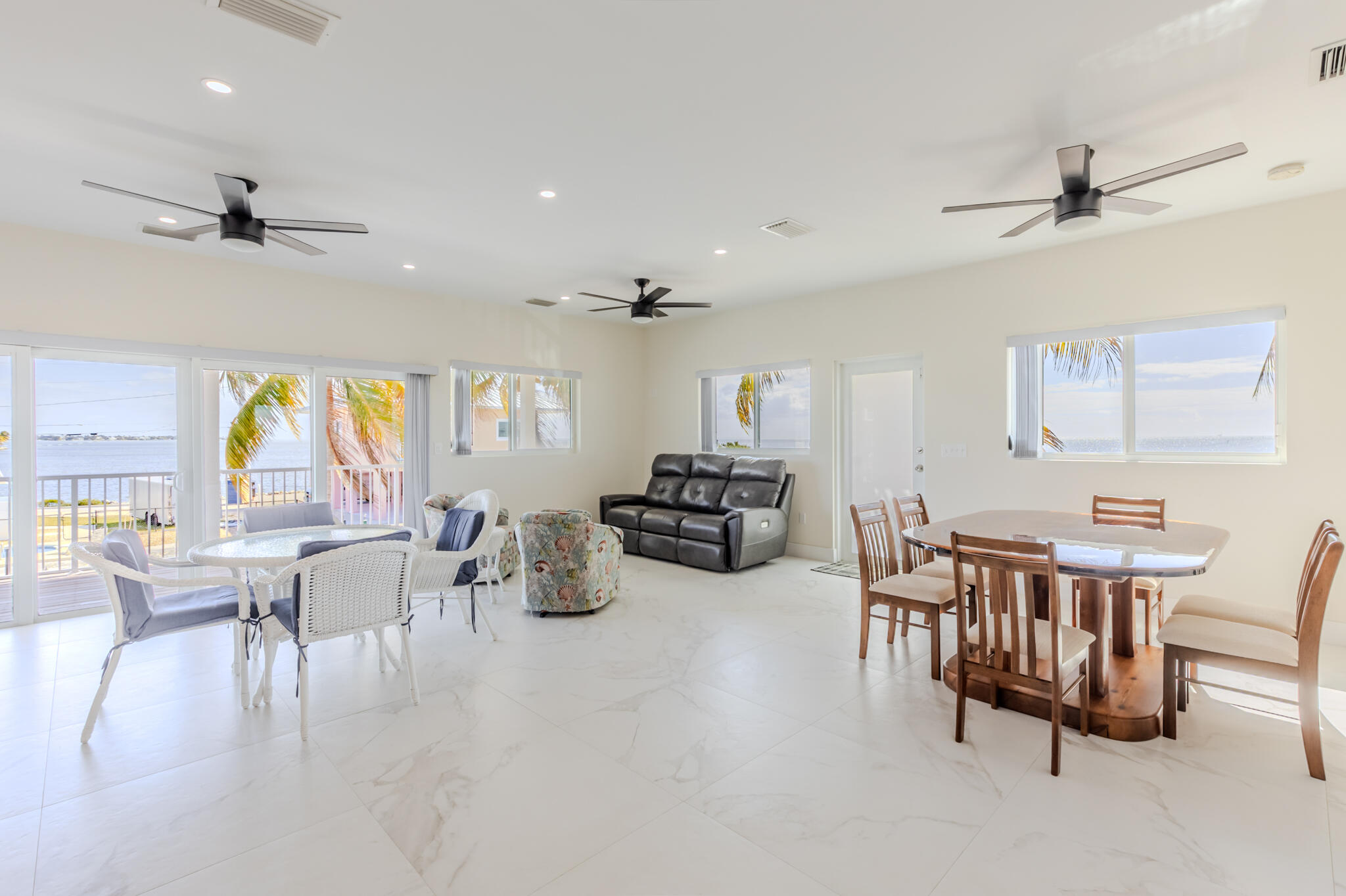 900 85th Street Marathon, FL 33050 - Photo 11 of 48 a view of a dining room and livingroom with furniture wooden floor a rug a flat screen tv