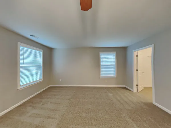 a view of an empty room with window and closet area