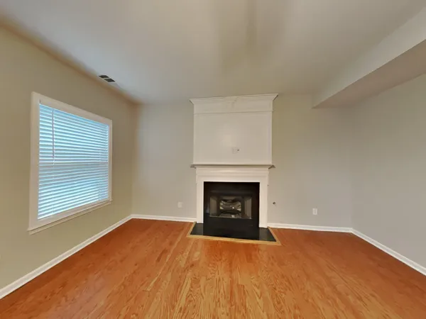 an empty room with a fireplace and window