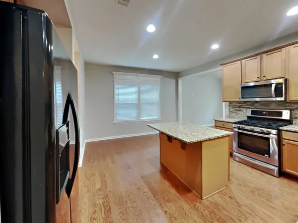 a kitchen with stainless steel appliances granite countertop a stove a sink and a refrigerator