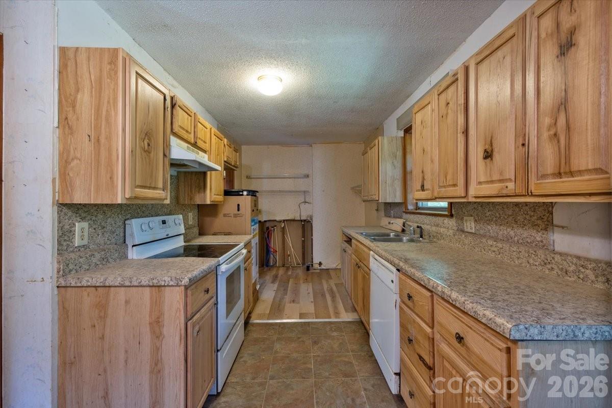 156 Old Sweetwater Road Robbinsville, NC 28771 - Photo 11 of 25 a kitchen with stainless steel appliances granite countertop a stove a sink and a refrigerator