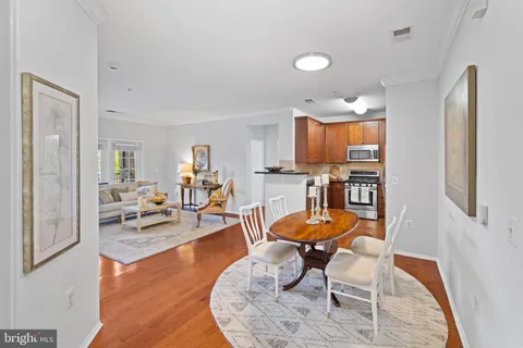 a living room with furniture and a dining table with wooden floor