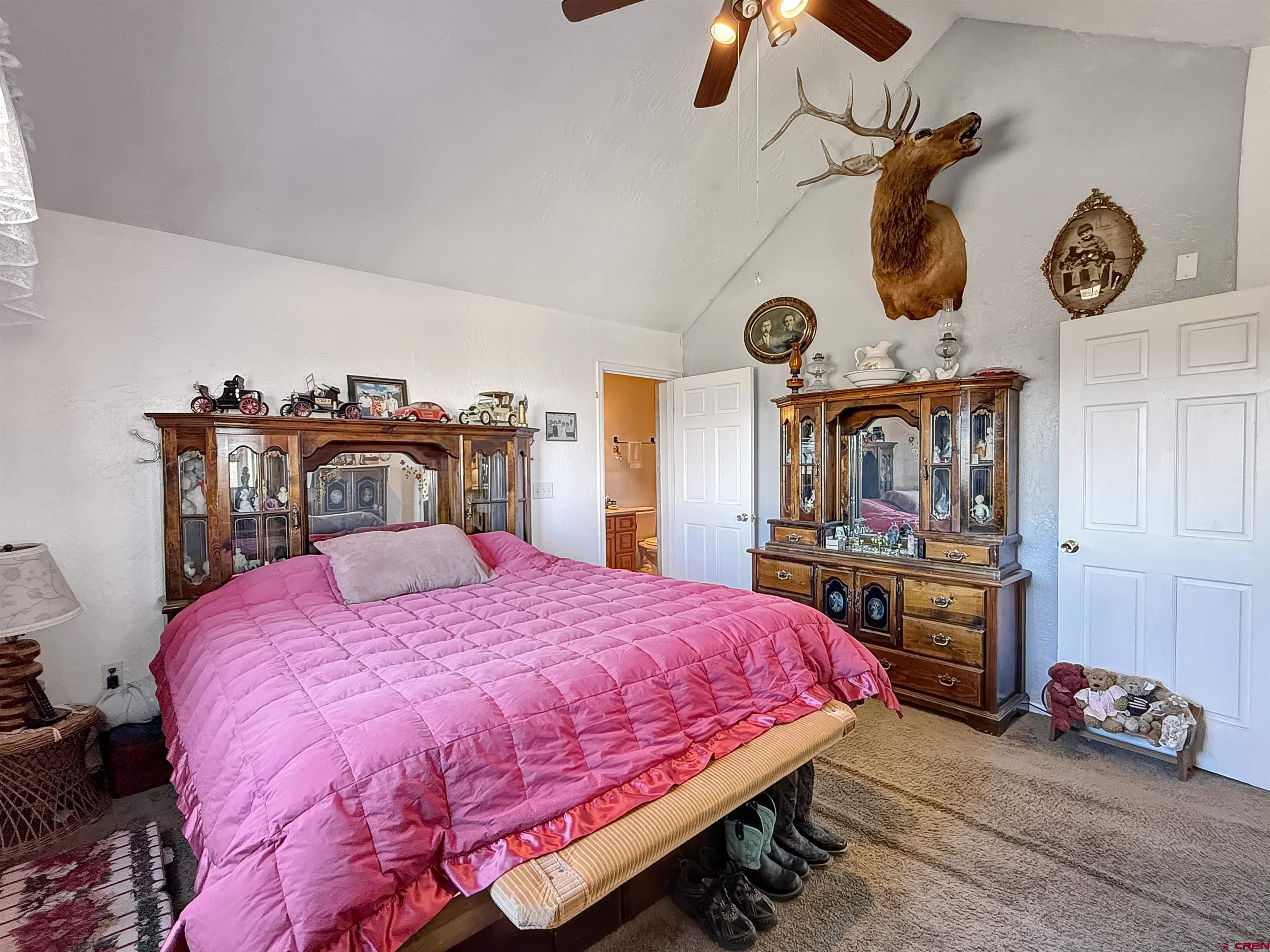 1174 3375th Road Crawford, CO 81415 - Photo 15 of 42 a bedroom with a bed and a chandelier