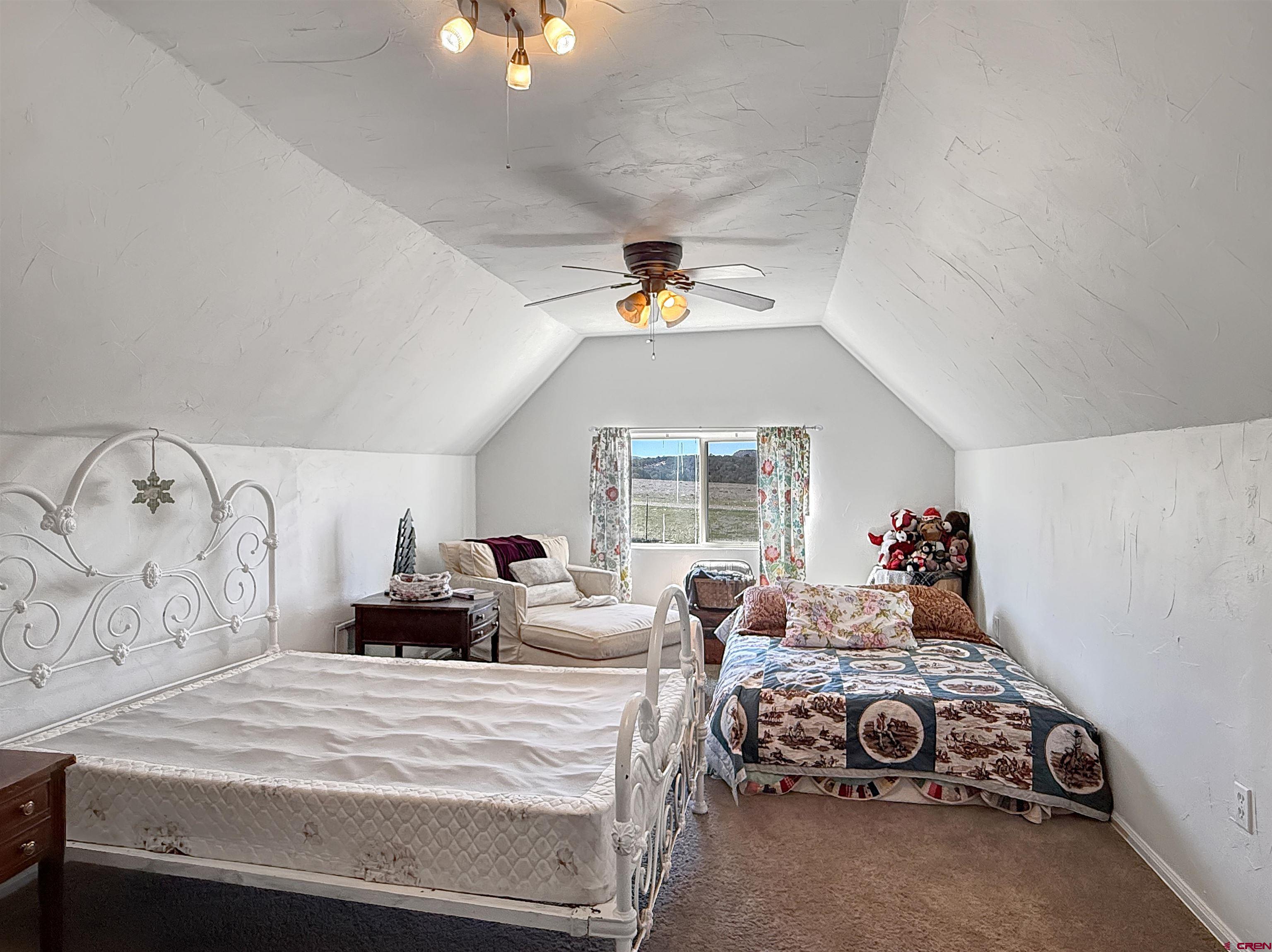 1174 3375th Road Crawford, CO 81415 - Photo 25 of 42 a bed room with a bed and a chandelier