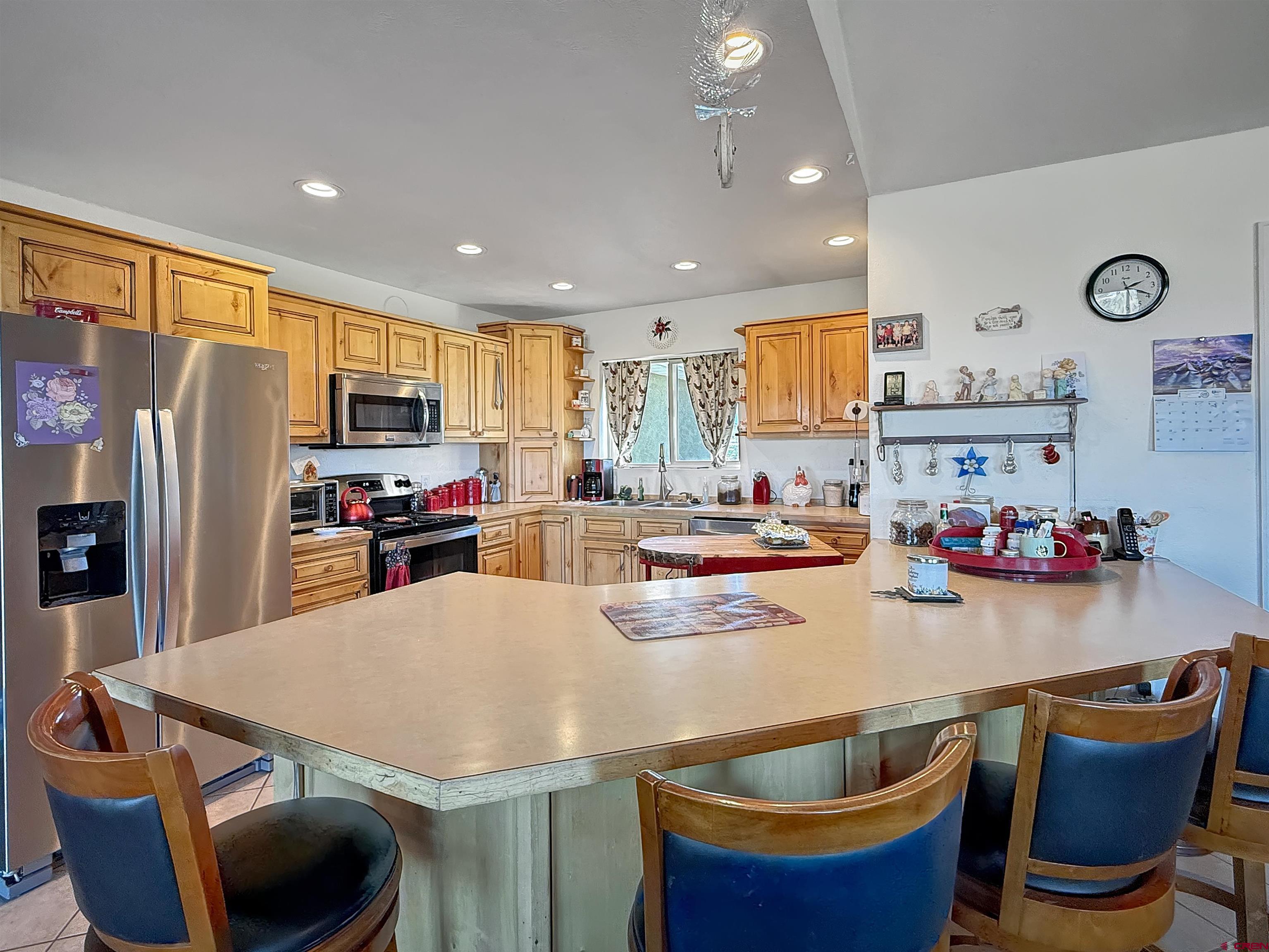1174 3375th Road Crawford, CO 81415 - Photo 8 of 42 a kitchen with stainless steel appliances granite countertop a sink a stove a refrigerator cabinets and chairs