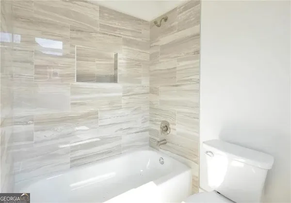 a kitchen with stainless steel appliances granite countertop a sink a stove a refrigerator and white cabinets