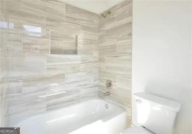 a kitchen with stainless steel appliances granite countertop a sink a stove a refrigerator and white cabinets