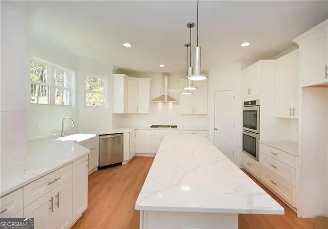 a kitchen with white cabinets and appliances
