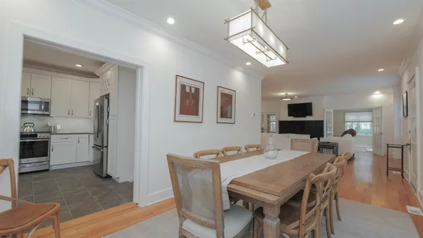 a view of a dining room with furniture a kitchen and chandelier