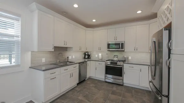 a kitchen with stainless steel appliances granite countertop white cabinets and a granite counter tops