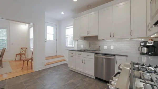 a kitchen with granite countertop white cabinets and white appliances