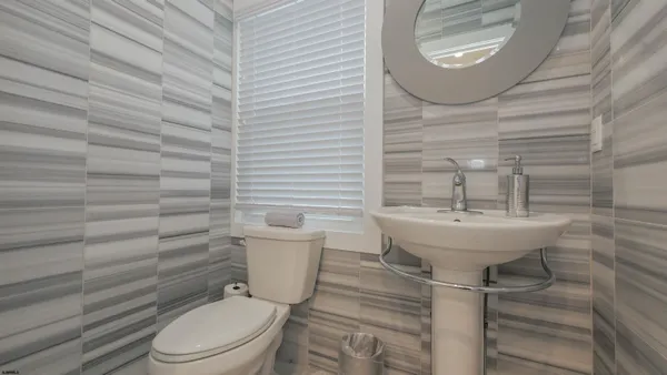 a bathroom with a sink a toilet and mirror