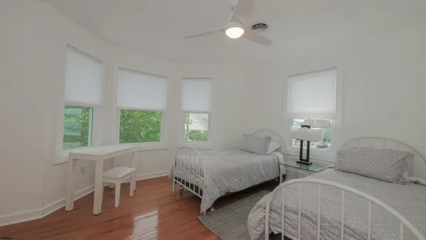 a bedroom with two beds and a large window
