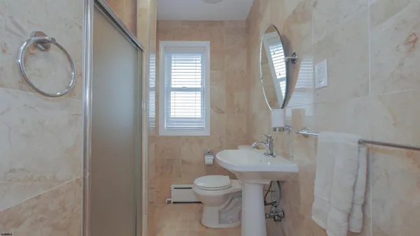 a bathroom with a toilet sink and mirror