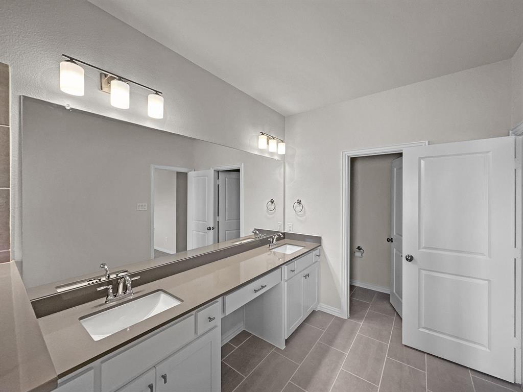 8876 Samara Street Frisco, TX 75035 - Photo 18 of 28 a spacious bathroom with a double vanity sink and mirror