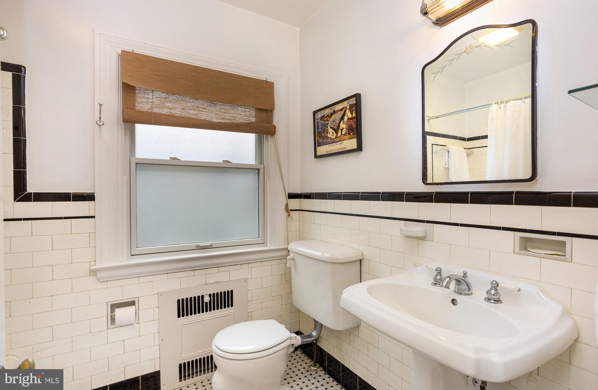 4412 Sedgwick Road Baltimore, MD 21210 - Photo 26 of 43 a bathroom with a sink a mirror and a toilet