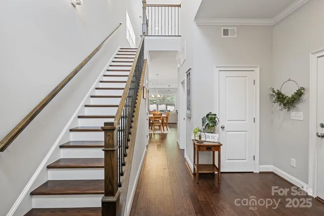 a view of a dining room and livingroom with furniture wooden floor a chandelier