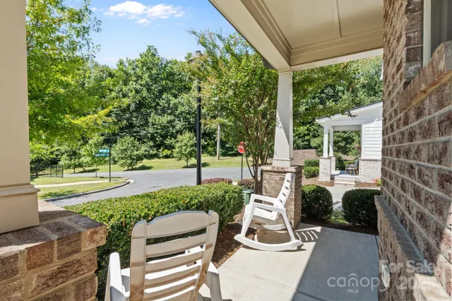 a view of a patio with table and chairs potted plants and a large tree