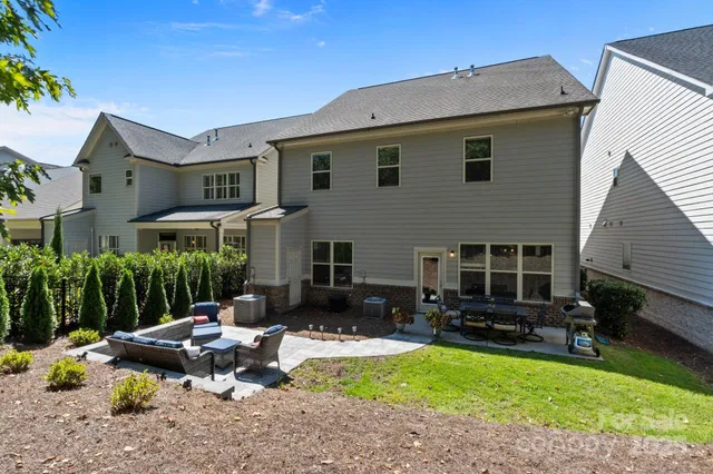 a backyard of a house with fire pit and chairs