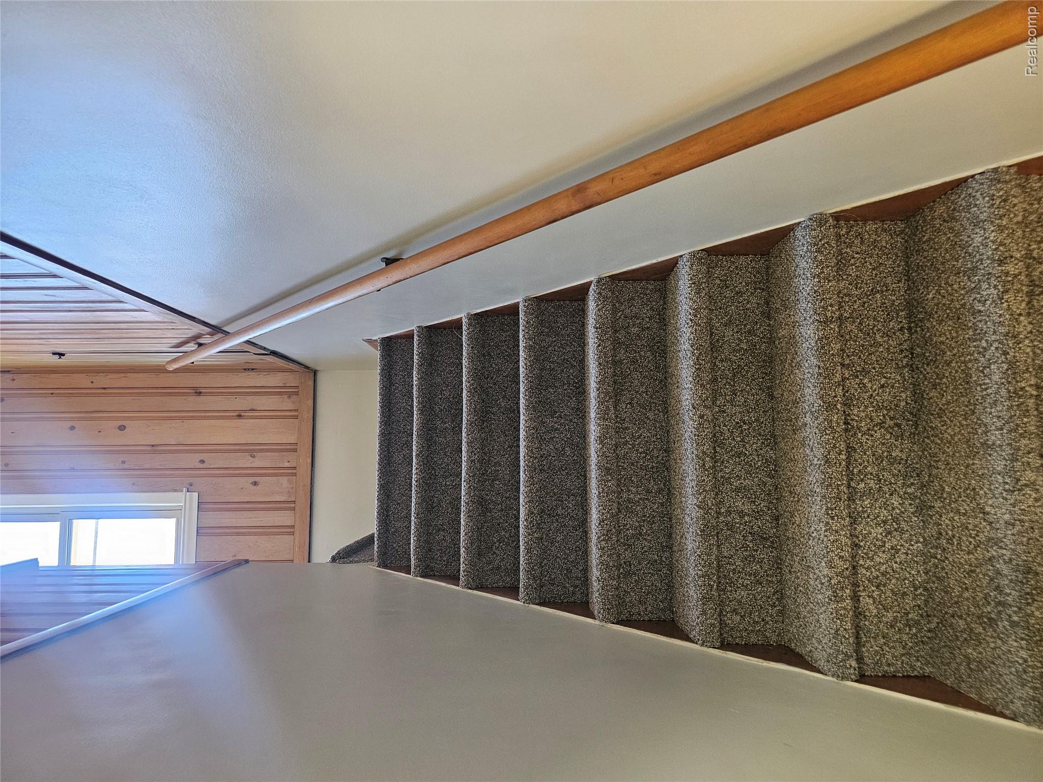 5240 Harvard Road Detroit, MI 48224 - Photo 14 of 18 Carpeted staircase featuring a light wood railing and a window with natural light