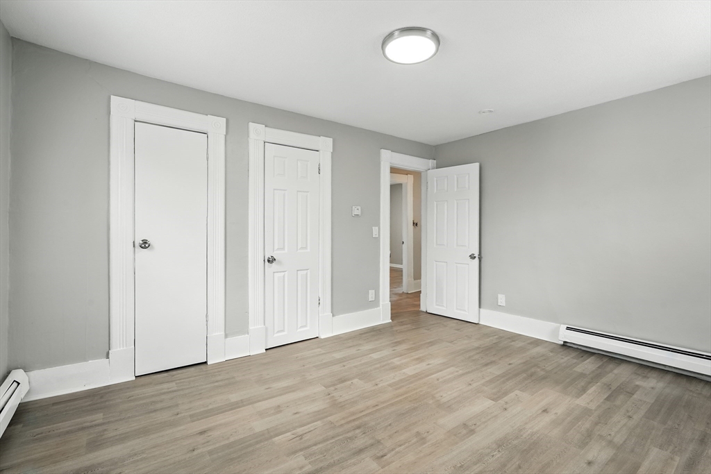 77 Coleman Street Springfield, MA 01109 - Photo 17 of 24 an empty room with wooden floor and windows