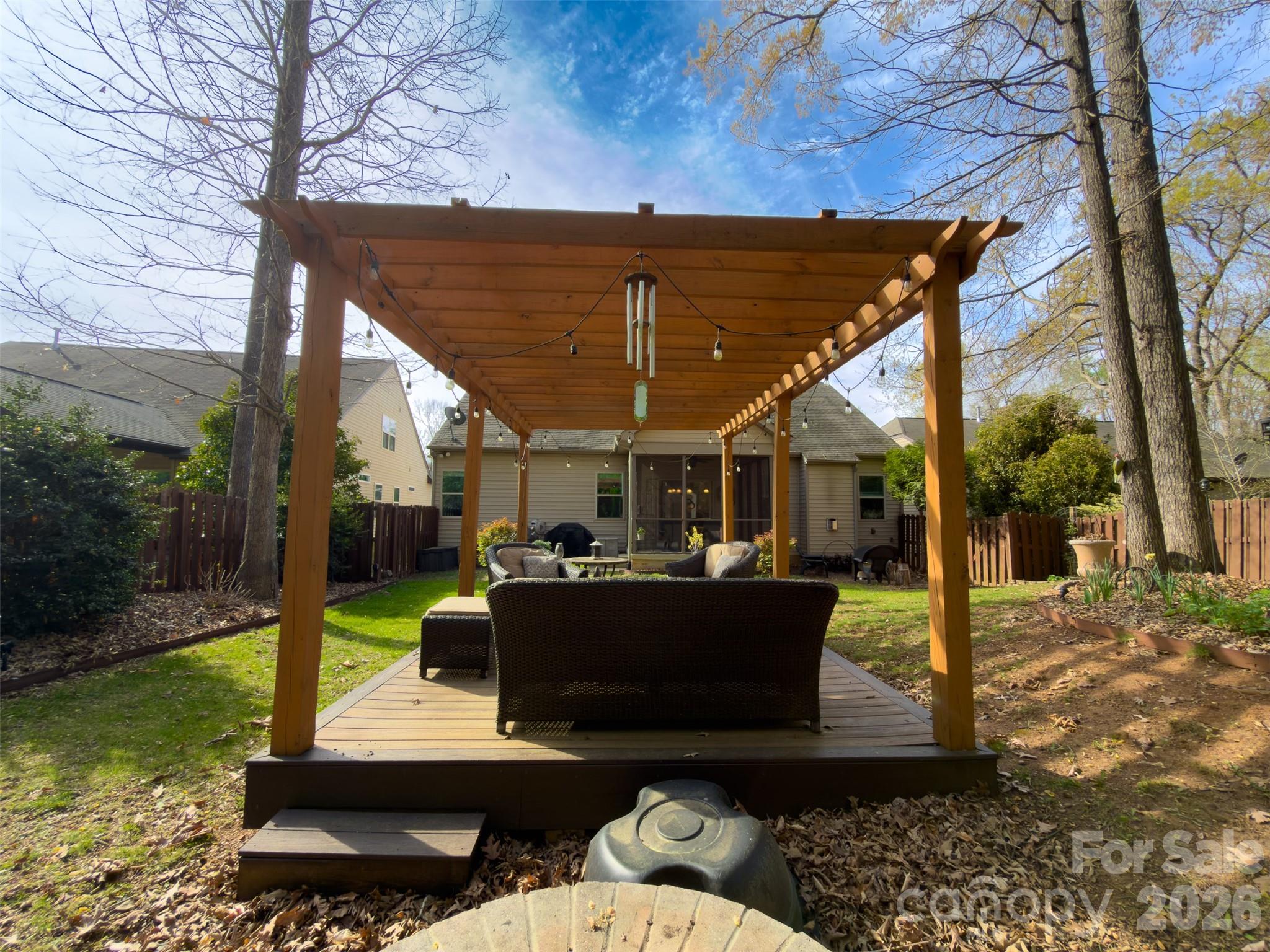 11824 Springpoint Lane Charlotte, NC 28278 - Photo 25 of 26 a view of a patio with table and chairs potted plants with wooden floor and fence