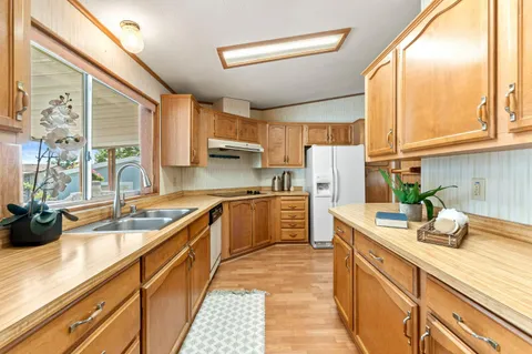 a kitchen with kitchen island granite countertop a sink appliances cabinets and a counter top space