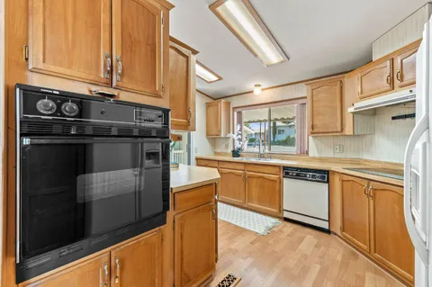 a kitchen with stainless steel appliances granite countertop a stove a sink and a microwave