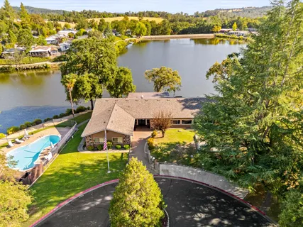 an aerial view of residential houses with outdoor space and lake view