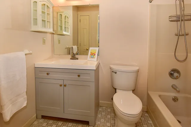 a bathroom with a sink a toilet and shower