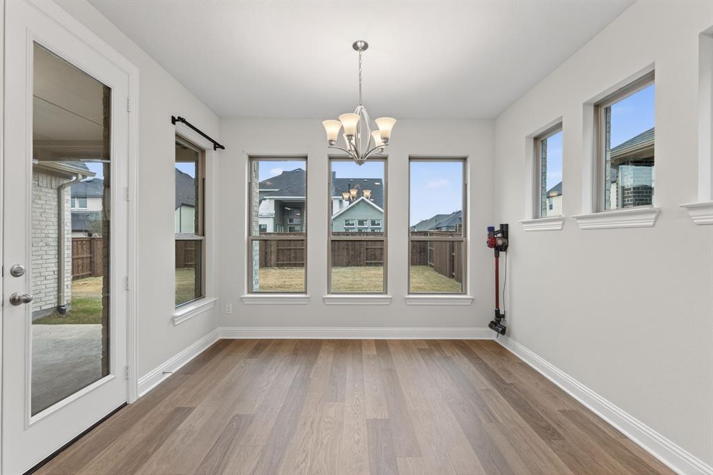 4150 Gambel Road Prosper, TX 75078 - Photo 18 of 39 Unfurnished dining area with a chandelier, plenty of natural light, and light wood-style floors