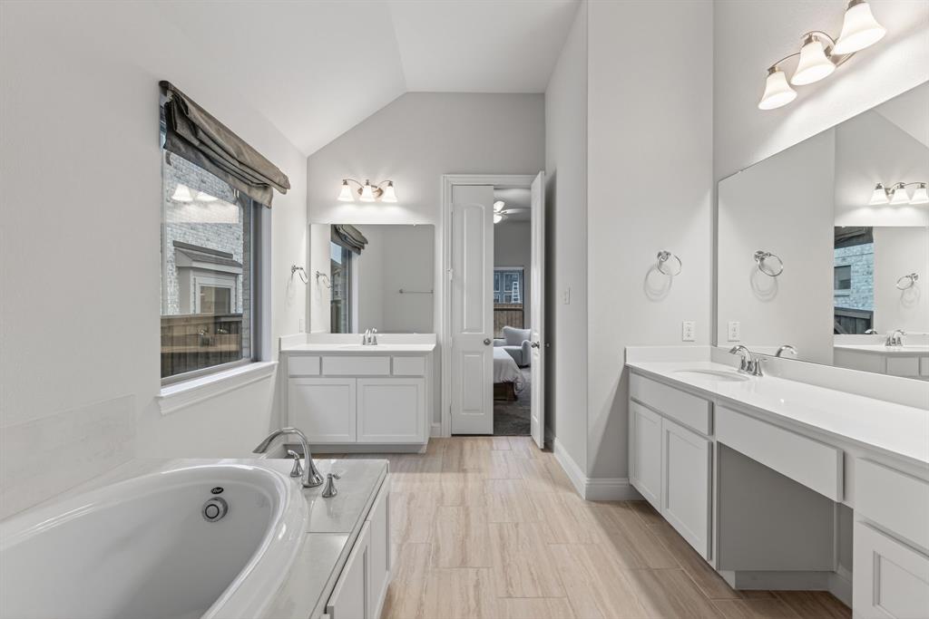 4150 Gambel Road Prosper, TX 75078 - Photo 22 of 39 Bathroom featuring two vanities, ensuite bathroom, a bath, and lofted ceiling