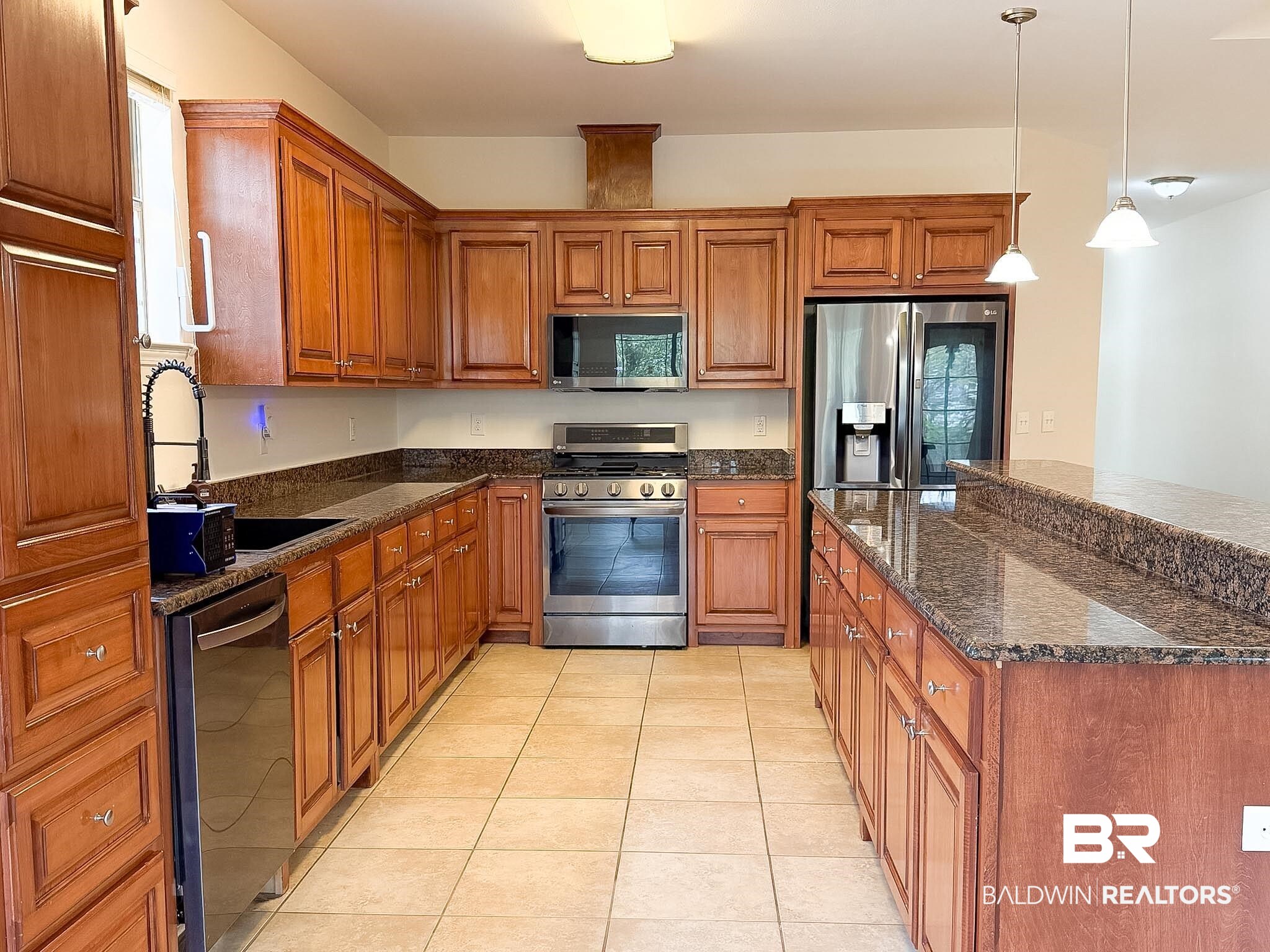 7332 Raintree Lane Gulf Shores, AL 36542 - Photo 6 of 21 Kitchen featuring wood finish cabinets, dark stone countertops, and stainless steel appliances
