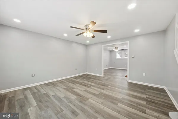 wooden floor in an empty room with a ceiling fan