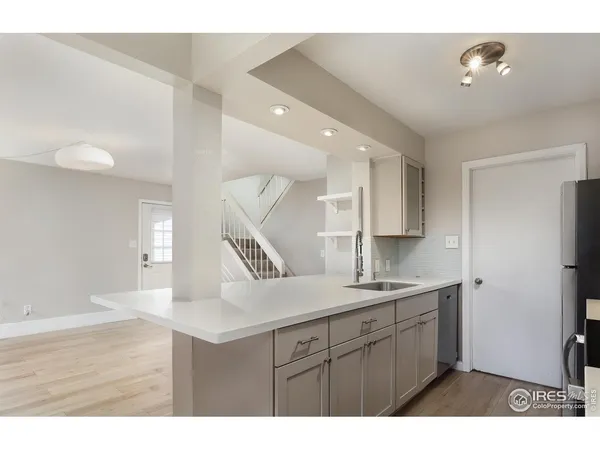 a kitchen with kitchen island a sink a stove a refrigerator and white cabinets