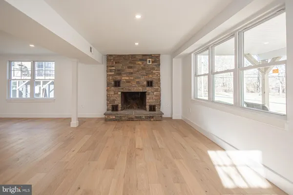 an empty room with windows and fireplace