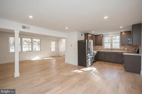 a view of a kitchen with refrigerator and wooden floor